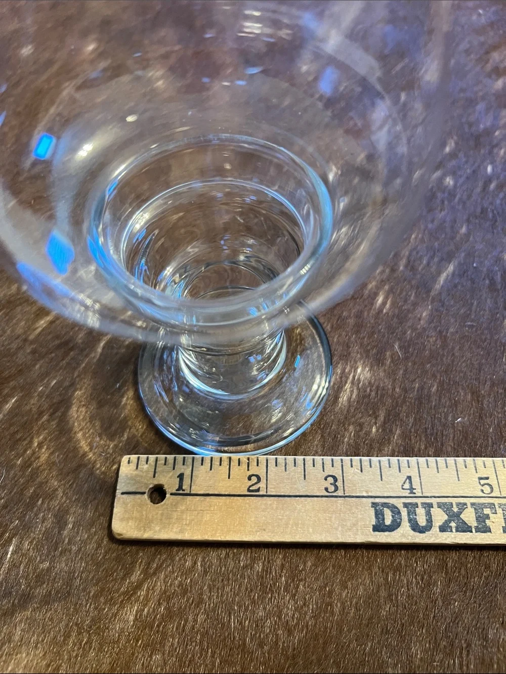 Clear glass hurricane candle holder features a pedestal base and a flared top